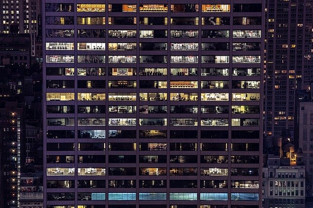 fachada de cristal de edificio de oficinas por la noche